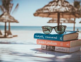 a pair of glasses on the book at the beach
