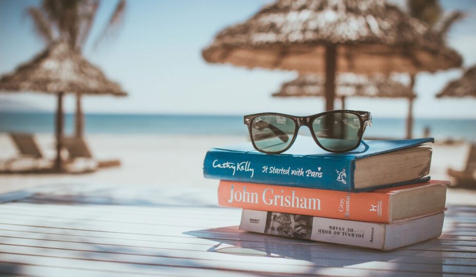 a pair of glasses on the book at the beach